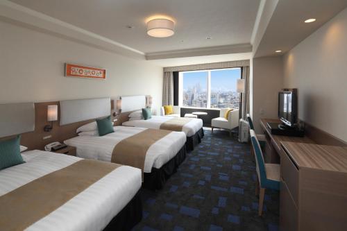 a hotel room with four beds and a television at Shibuya Excel Hotel Tokyu in Tokyo