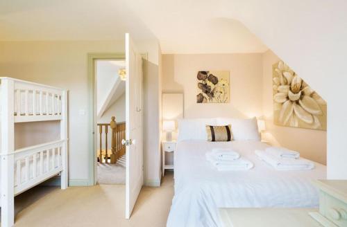 a bedroom with a white bed and a staircase at Grove Lodge in Gosport