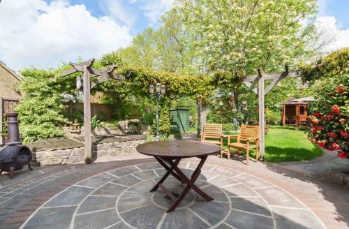 a picnic table in a backyard with a pergola at Grove Lodge in Gosport