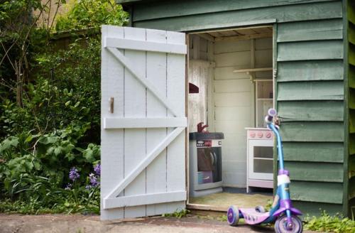 a scooter parked outside of a house with an open door at Grove Lodge in Gosport