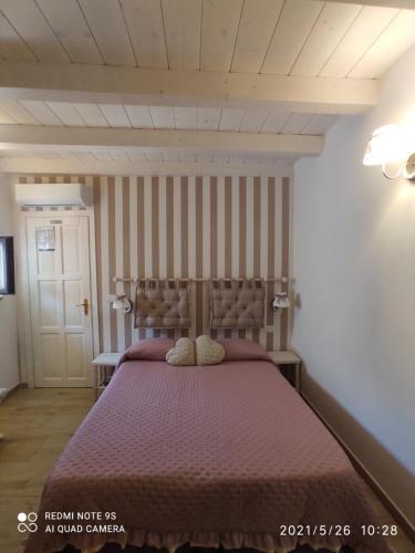 a bedroom with a bed with a purple bedspread at B&B La Maison Del Borgo Antico in Bari