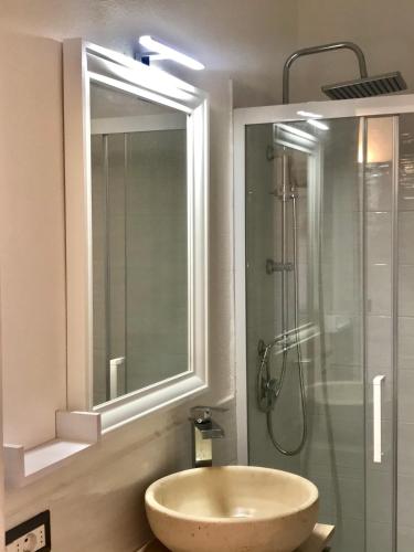 a bathroom with a sink and a shower with a mirror at Charme House Palau in Palau