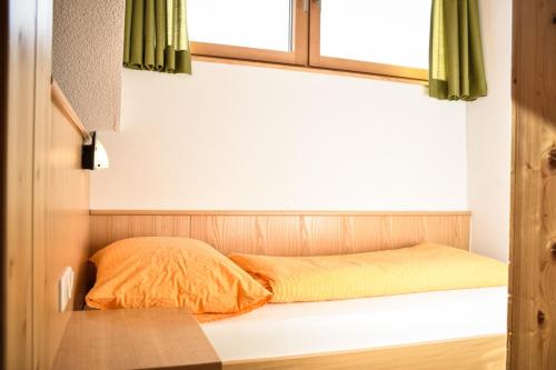 a bed in a room with a window at Haus Alpenblick in Schröcken