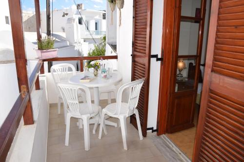 a white table and chairs on a balcony at Naoussa Center Cycladic House in Kampos Paros