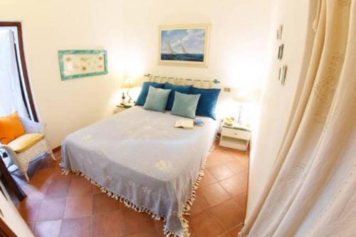 - une chambre avec un lit et des oreillers bleus dans l'établissement TARA Village, à Porto Pollo