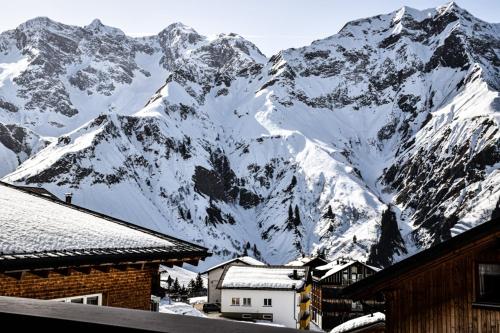 a snow covered mountain in front of a village at Haus Alpenblick in Schröcken