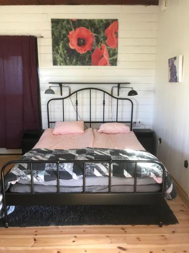 um quarto com uma cama preta e almofadas cor-de-rosa em Tågmagasinet Fidenäs em Burgsvik