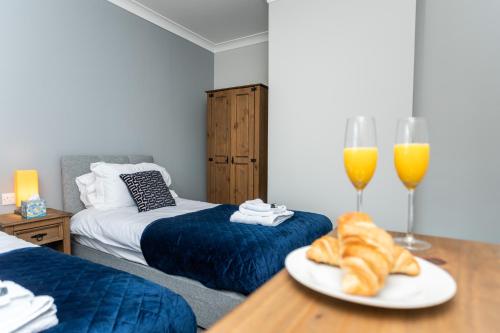 a room with two beds and two glasses of orange juice at The Old Clubhouse in Copley