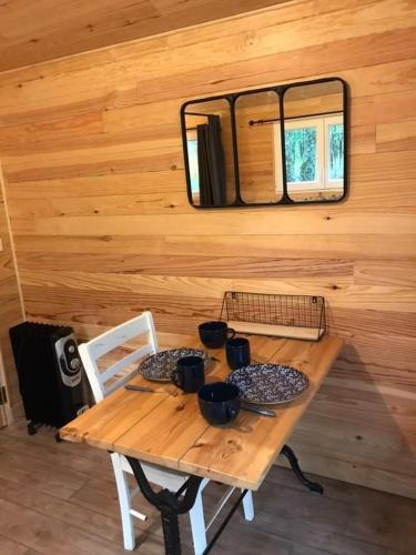a wooden table and chairs in a cabin with a mirror at LA SAPINEDE in Saint-Vincent-de-Paul