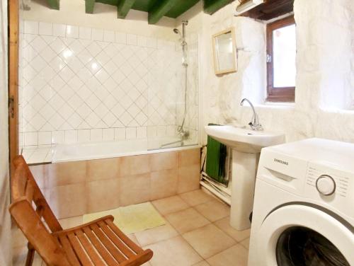 une salle de bain avec une machine à laver et un lavabo dans l'établissement Maison charmante à Saint-Basile avec jardin et cheminée, à Saint-Basile