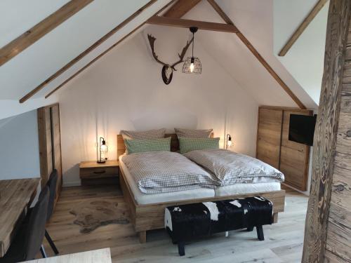 a bedroom with a bed and a tv in a attic at Gasthof Dörsbachhöhe in Herold