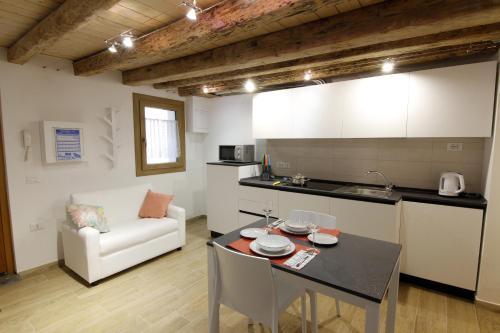 een keuken en een woonkamer met een tafel en een bank bij Tre Raggi Apartment in Venetië