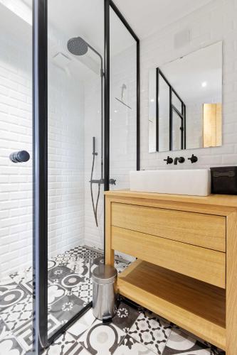 une salle de bain avec un lavabo et un miroir dans l'établissement L' Annexe du Cosmopolitain, à Honfleur