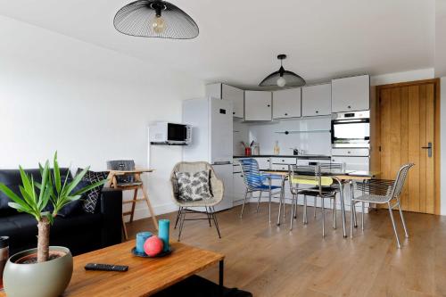 een woonkamer en een keuken met een tafel en stoelen bij L' Annexe du Cosmopolitain in Honfleur