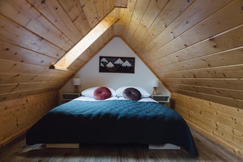 a bed in a room with a wooden ceiling at Maciejowy Dwór in Zakopane