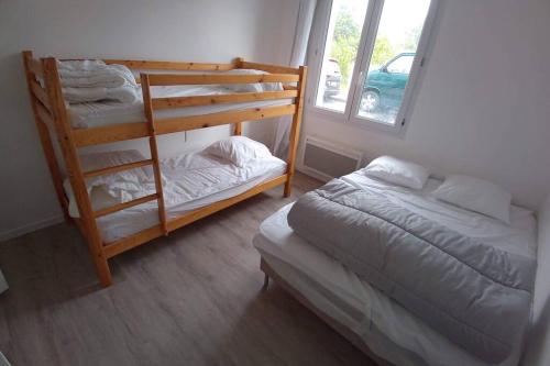 une chambre avec deux lits superposés et une fenêtre dans l'établissement Maison aux Mathes, aux Mathes
