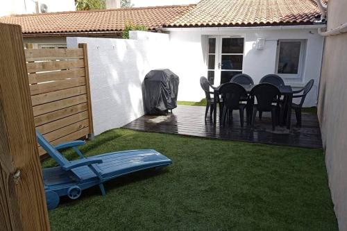 une arrière-cour avec une table et des chaises sur une terrasse dans l'établissement Maison aux Mathes, aux Mathes