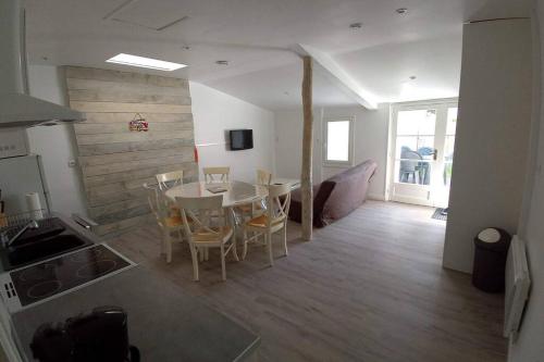 une cuisine et une salle à manger avec une table et des chaises dans l'établissement Maison aux Mathes, aux Mathes