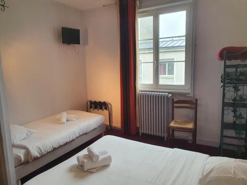 a small room with two beds and a window at Hotel Kelig in Brest