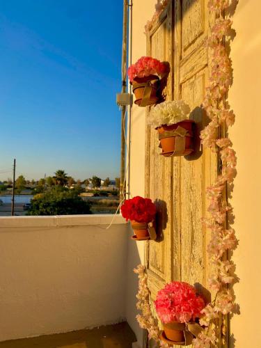 una puerta con flores al lado de un edificio en Il Mare in Tasca - Casa Vacanze - loc.Torre Lapillo (LE) - Salento, en Torre Lapillo