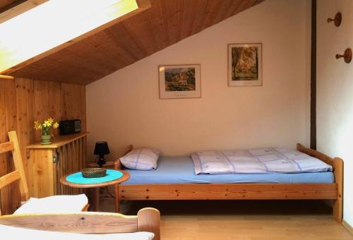 a small bedroom with a bed and a table at Ferienwohnung Aigner in Bischofswiesen