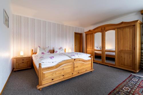 Un dormitorio con una gran cama de madera y una ventana en Ferienwohnung von Postel, en Büsumer Deichhausen