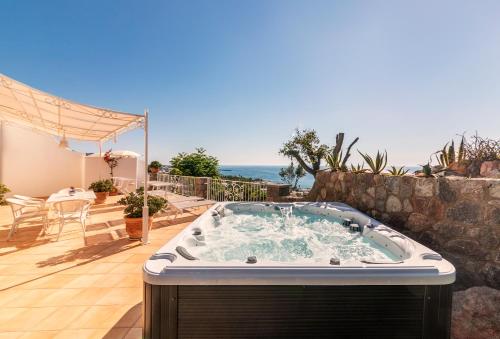 a jacuzzi tub on a patio with a table at Villa dei Lecci - 7 Luxury villas with private pool or jacuzzi in Ischia
