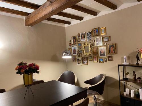 Appartamento Frida في بارما: غرفة طعام مع طاولة وكراسي وصور على الحائط