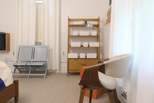 a bedroom with a desk and a chair and a lamp at The Hotel Marblehead in Marblehead