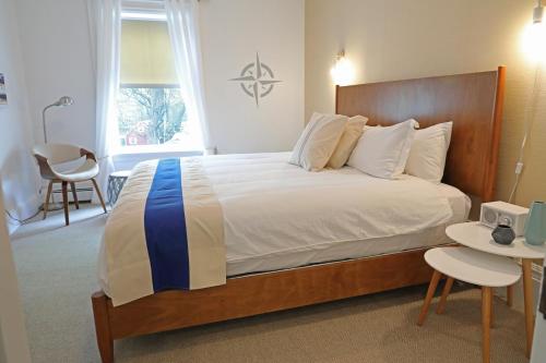 a bedroom with a large bed with a wooden headboard at The Hotel Marblehead in Marblehead