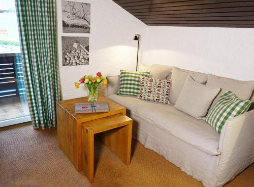 a living room with a couch and a table with flowers at Schittlerhaus in Oberstdorf