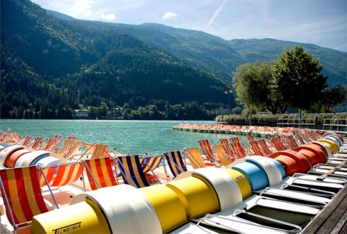 a row of beach chairs sitting next to a body of water at Residence Stefenine in Molveno