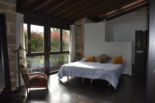 ein Schlafzimmer mit einem Bett und einem großen Fenster in der Unterkunft Ribeira sacra ourense in Ourense