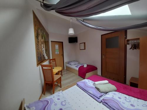 a small bedroom with two beds and a chair at Green Hostel in Krakow