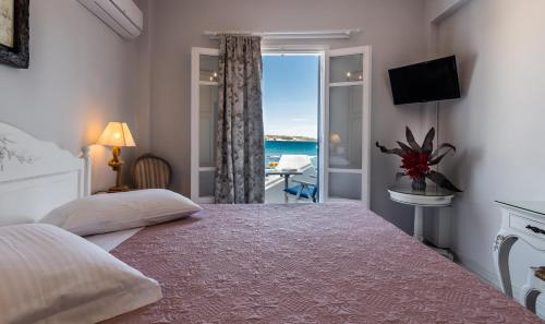 a bedroom with a bed with a view of the ocean at Villa Zampeta in Adamas