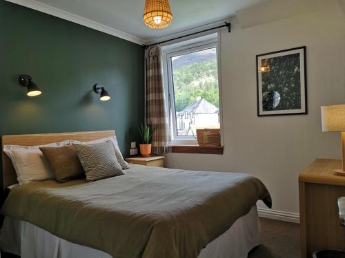 a bedroom with a large bed and a window at Forest View Guesthouse, Kinlochleven WHW in Kinlochmore