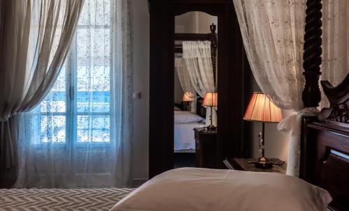 a bedroom with a bed and a large window at Villa Zampeta in Adamas