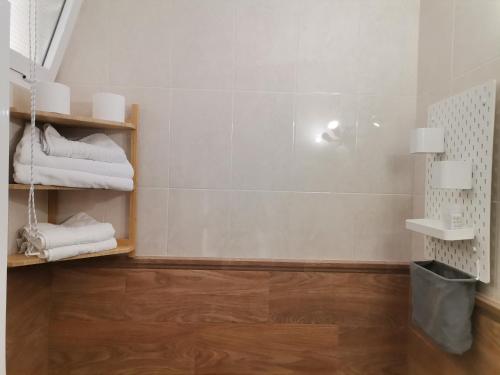 bagno con asciugamani bianchi su pavimento in legno di Apartamentos La Mar Chica a Benalmádena