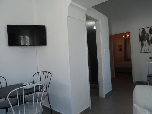 a dining room with a table and a television on a wall at NEOKLASSIKO KOUKOULI in Fira