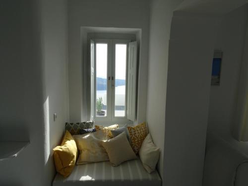 a couch sitting in a room with a window at NEOKLASSIKO KOUKOULI in Fira
