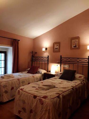 a bedroom with two beds and a window at Viviendas Turísticas Los Arrayanes in Ronda