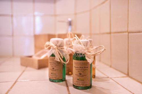 tre bottiglie sedute sul pavimento in un bagno di Hotel Macondito Holbox a Isola Holbox