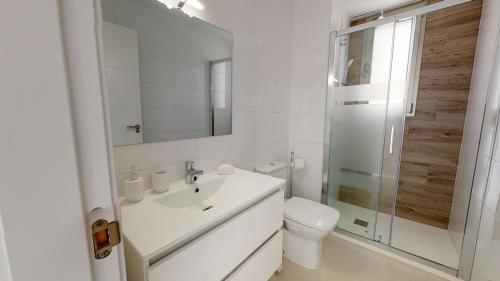 a white bathroom with a sink and a toilet at Villa Mercurio - A Murcia Holiday Rentals Property in Los Alcázares