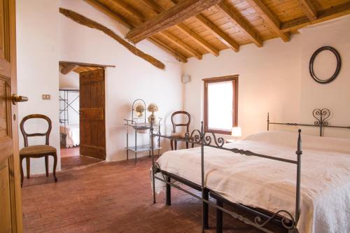 1 dormitorio con 1 cama, mesa y sillas en Agriturismo Corte Galvagnina, en Cesole