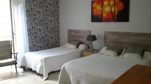 - une chambre avec deux lits, une chaise et un tableau dans l'établissement Gîte de la Forêt, à Paray-le-Monial