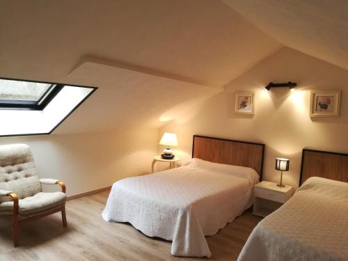 - une chambre avec deux lits, une chaise et une fenêtre dans l'établissement Gîte de la Forêt, à Paray-le-Monial