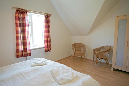 1 dormitorio con 1 cama, 2 sillas y ventana en Eystri-Solheimar, en Vík