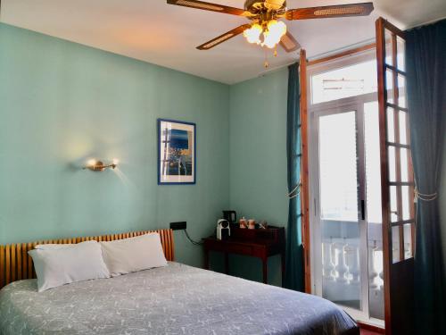 a bedroom with a bed and a ceiling fan at Privat Hotel Liberty Sitges in Sitges