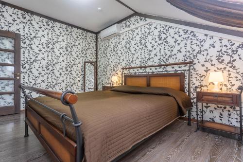 a bedroom with a bed in a room with wallpaper at Hotel Pechory-Park in Pechory