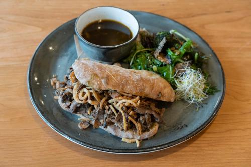 a plate with a pulled pork sandwich and a salad at Hotel Zed Tofino in Tofino